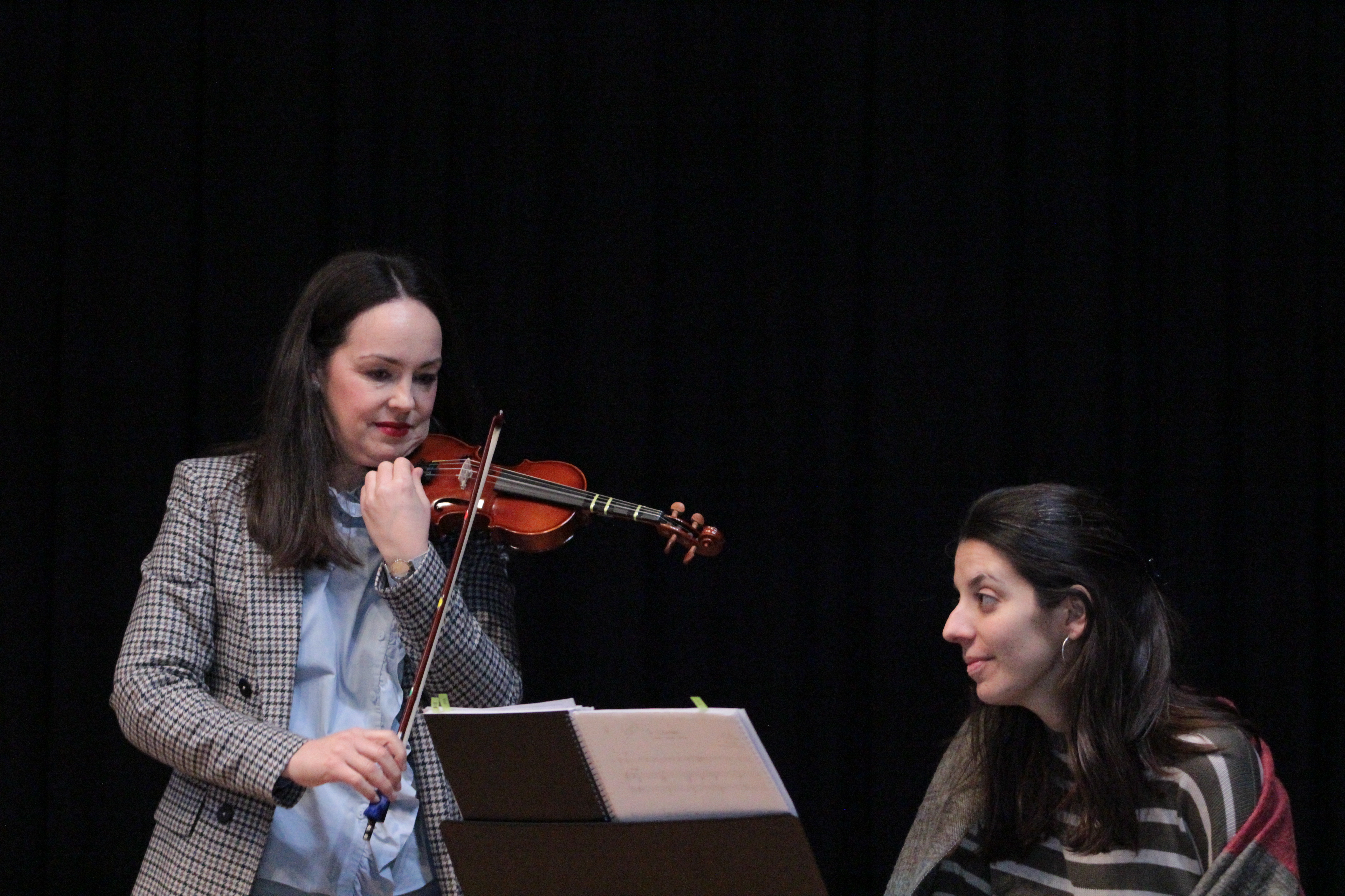  •	Pianista acompañante dando un la a la profesora de violín para afinar el instrumento de un alumno pequeño