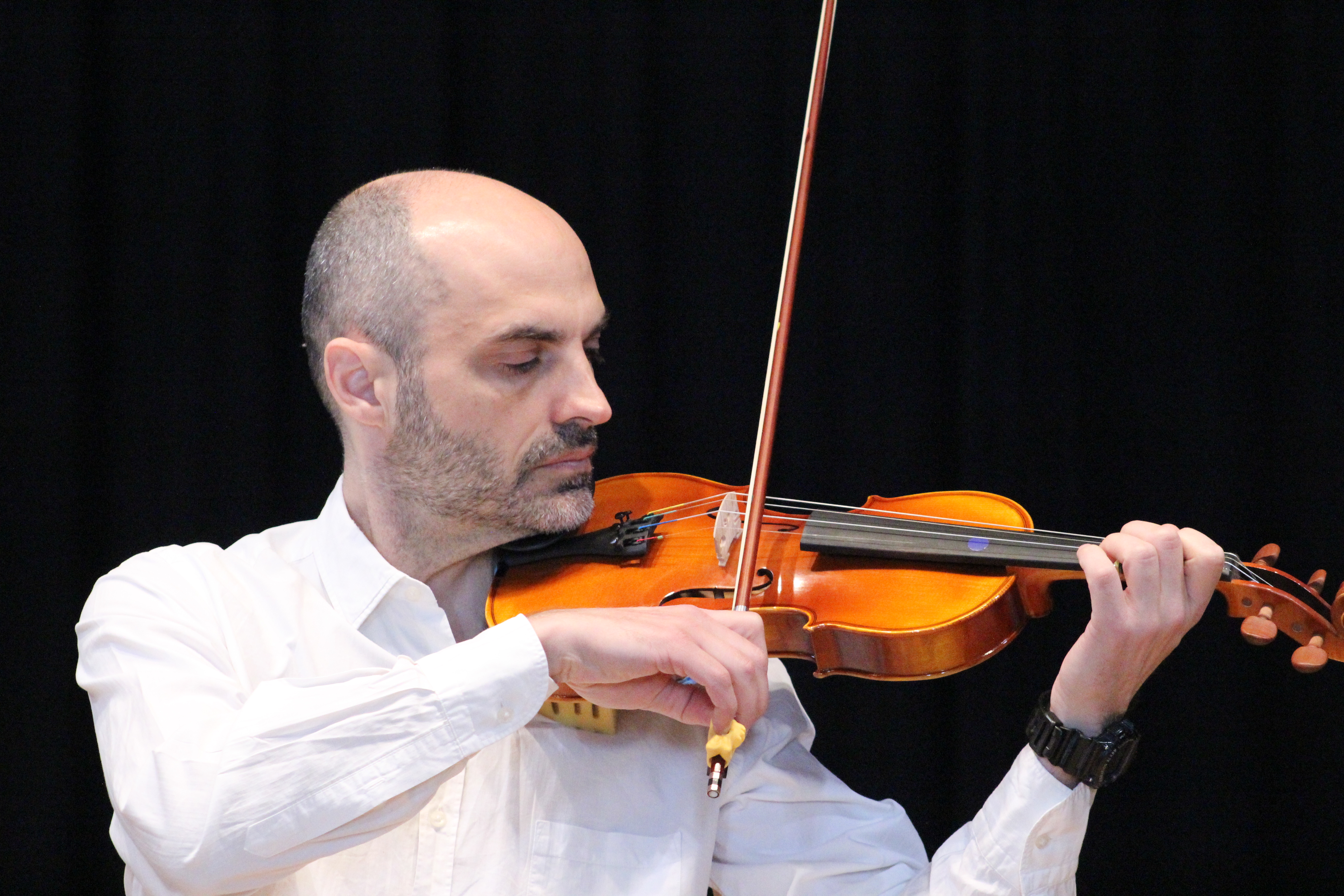 Adulto tocando el violín para dar ejemplo a su hijo, parte fundamental del Método Suzuki