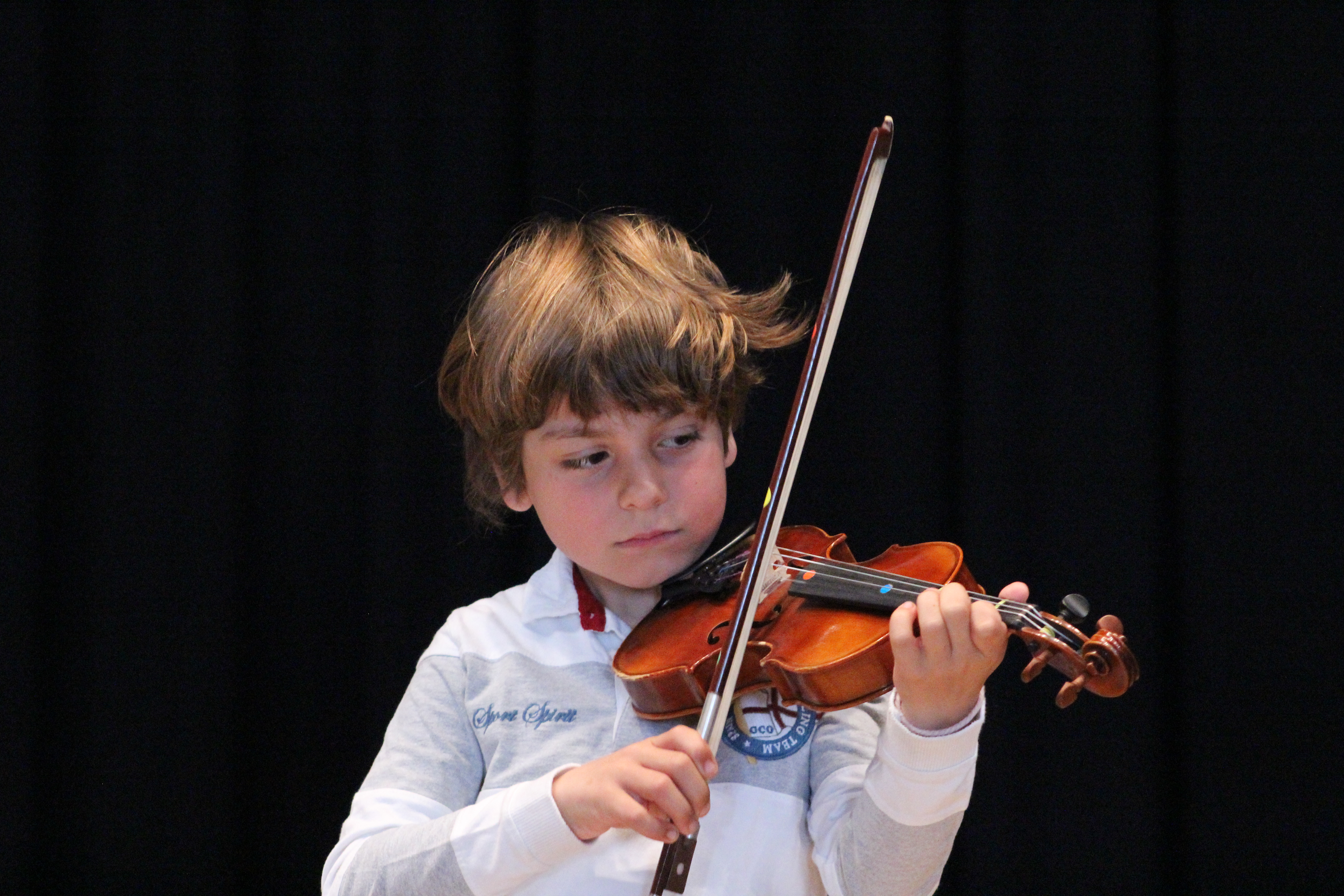 Niño tocando el violín con una buena sujeción del arco, aspecto fundamental para obtener un buen sonido