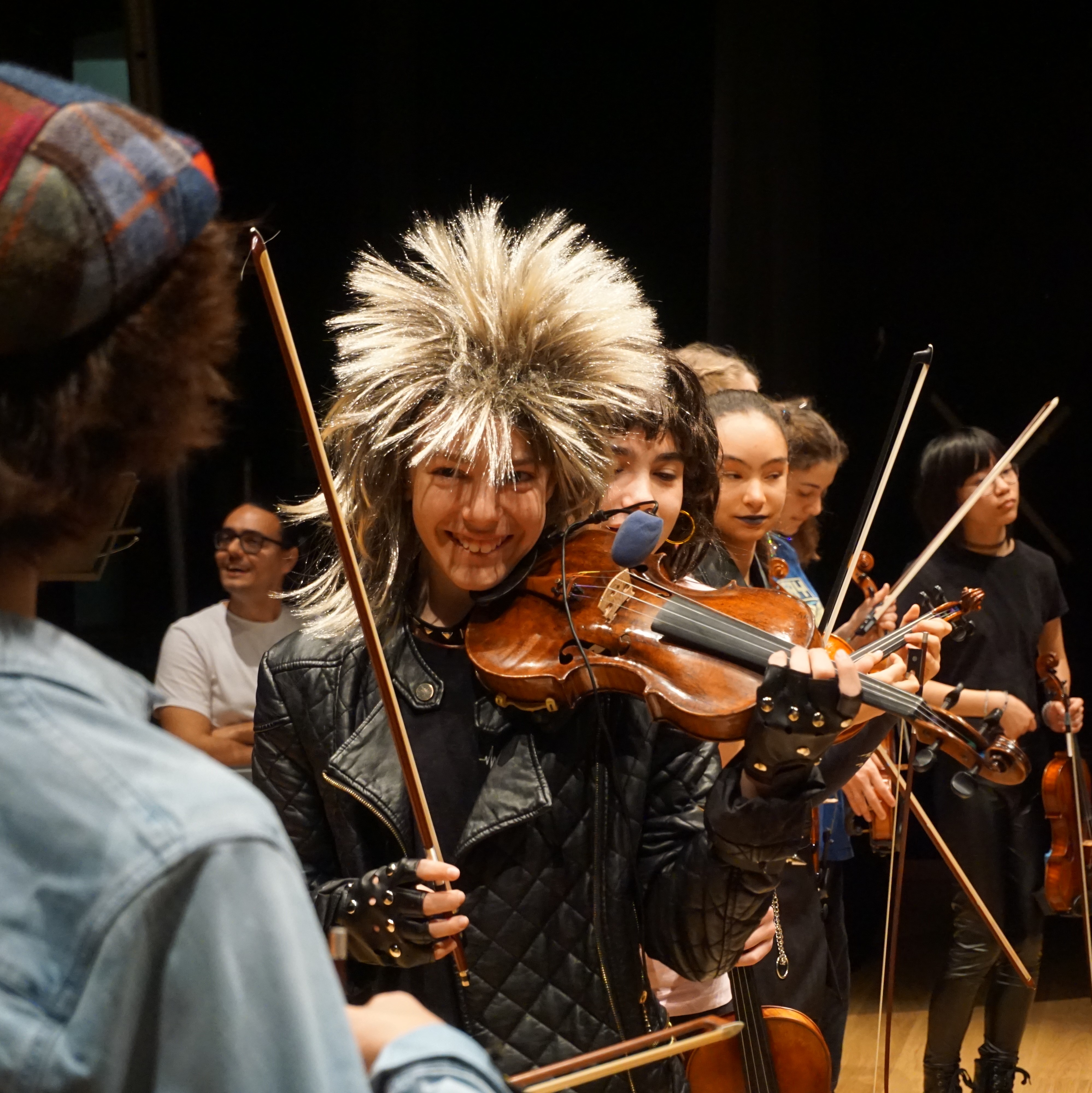 Alumnos adolescentes de violín pasándolo bien en el ensayo general del concierto de grupo de Rock&Roll